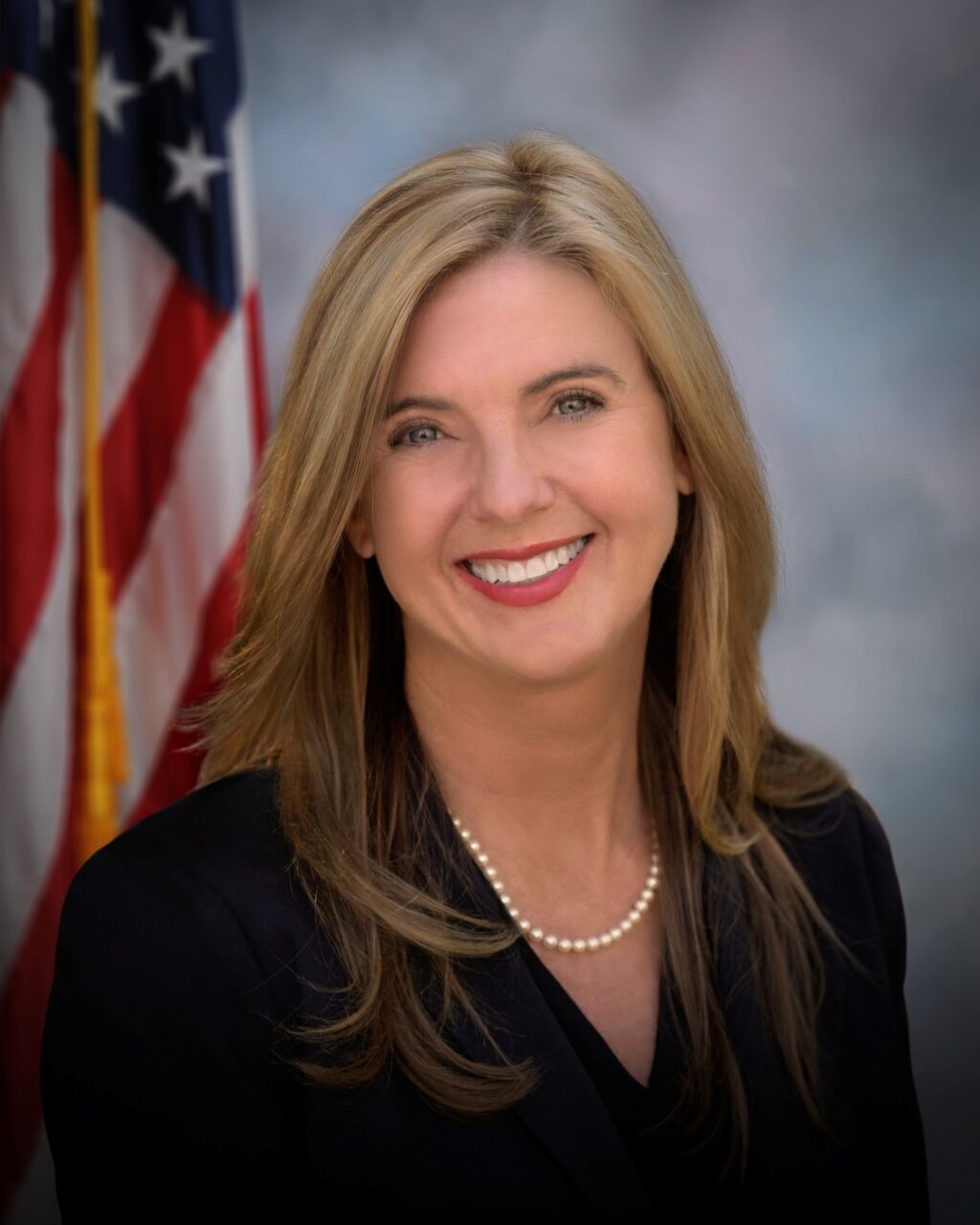 Kelly Long Headshot With Flag